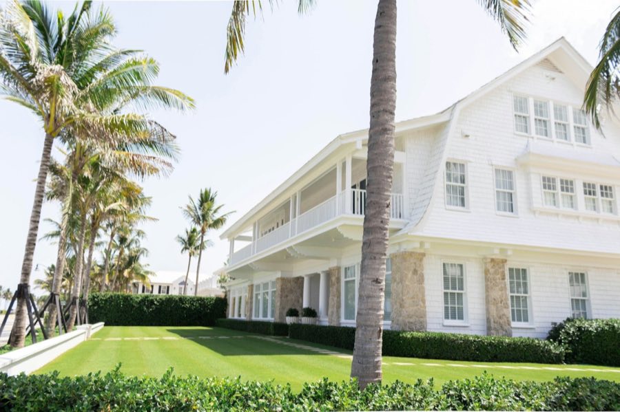 White single-family home framed by palm trees